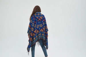 Detailed back view of a hooded poncho with blue ethnic jacquard patterns and black tassels