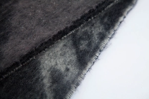 Close-up of thick grey star patterned scarf showing plush texture and neat stitching