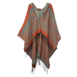 Détail du poncho en maille jacquard ethnique avec franges et capuche en orange et gris