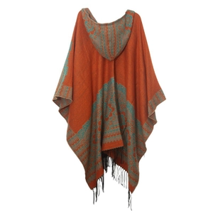 Détail du motif jacquard ethnique orange et bleu avec ourlet à pompons noirs sur poncho