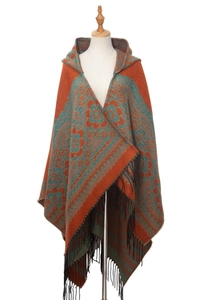 Détails d'un poncho ethnique avec motifs jacquard orange et bordures à franges noires