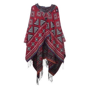 Close-up of red geometric knitted pattern and black tassel fringe on the bohemian poncho