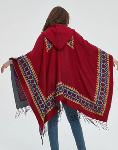 Vue arrière du poncho rouge à capuche avec motifs de cœurs bleus et glands noirs