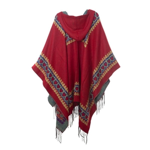 Détail du poncho rouge à capuche avec motifs de cœur et pompons à franges noirs