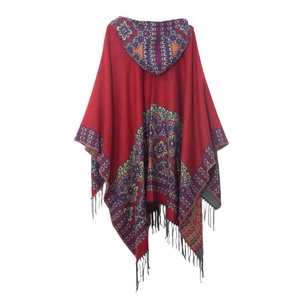 Détail d'un poncho rouge à capuche bohème avec motifs mandala et franges noires