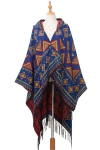 Detail of navy hooded poncho featuring ethnic geometric patterns and long black tassels