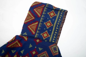 Close-up detail of geometric tribal pattern and thick knit texture on hooded poncho