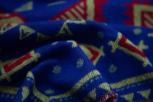 Close-up of ethnic jacquard weave fabric with geometric patterns and fringe detail