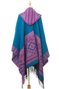 Détail du poncho en tricot bohème avec motifs mandala ethniques et pompons à franges noirs