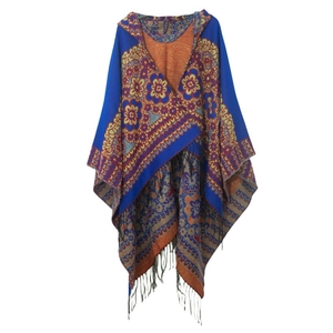 Vue détaillée d'un poncho bohème bleu roi avec motifs jacquard orange et longues franges