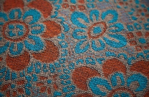 Détail macro du tricot jacquard avec motifs de soleil et textures géométriques précises