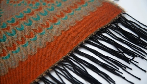 Gros plan d'un poncho bohème à capuche avec motifs géométriques et franges noires