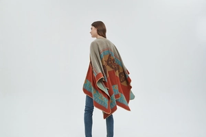 Detailed back view of orange knit shawl with ethnic geometric patterns and overlock edges