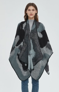 Detail of grey jacquard knit shawl with marble pattern and black stitched edges