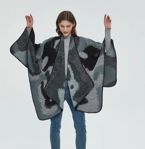 Detail view of the thick double-sided jacquard knit poncho with abstract pattern