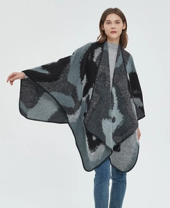 Detail of grey and blue jacquard knit shawl showing high-quality stitching and texture