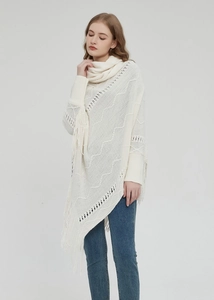Detaillierte Strickstruktur und lange Fransen an einem weißen Rollkragen-Poncho-Umhang