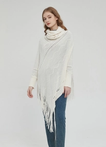 Details des cremeweißen Strickponchos mit weichen Fransen und gehäkelten Wellenmustern