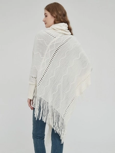Detailansicht der Rückseite eines cremeweißen Strickponchos mit Quasten und Mustern