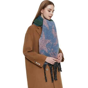 Thick knit star pattern scarf with tassels worn over a camel wool coat in winter style