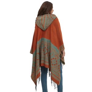 Poncho à capuche en tricot orange avec motifs jacquard bleus et bordures à franges noires