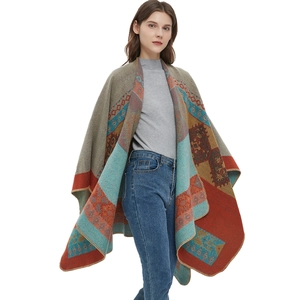 Bohemian geometric knit poncho shawl with orange jacquard pattern and fringe detailing