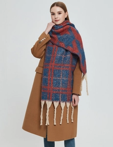 Detail eines blau-orangen karierten Winterschals mit weicher Strickstruktur und Fransen