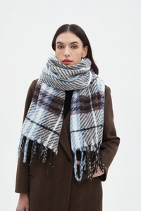 Detail of a large plaid scarf with long fringes and thick woven texture in blue and brown
