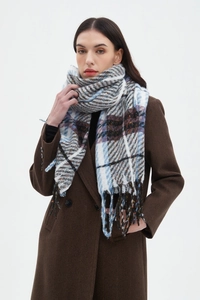 Detail of blue and brown plaid scarf with fringe texture on a brown herringbone coat