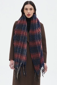 Dettaglio di sciarpa a quadri vintage con nappe rosse e blu su cappotto di lana