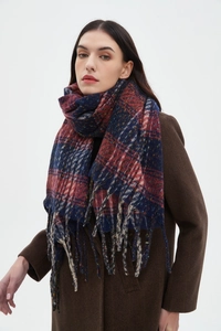 Dettaglio di sciarpa a quadri blu navy e bordeaux con nappe indossata su un cappotto