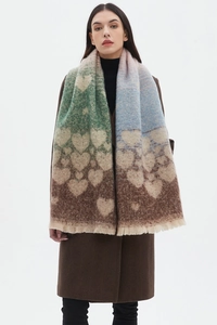 Detail of thick knit scarf featuring heart jacquard patterns and soft fringe edges