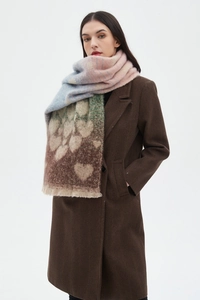Detailed texture of thick gradient scarf featuring large heart patterns and fringe edges
