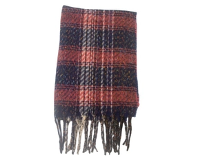 Dettaglio della trama a quadri rossi e neri con texture tweed screziata e frange decorative