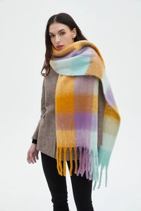 Close-up of thick checkered scarf with long fringe tassels and soft knit texture