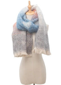 Close-up of thick knitted scarf with blue orange gradient texture and long tassels