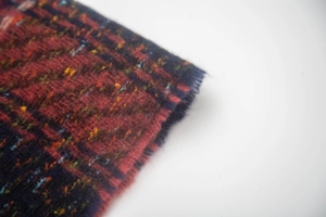 Dettaglio della trama della sciarpa scozzese rossa con nappe e bordi sfrangiati
