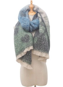 Detailed view of thick knit scarf with blue heart jacquard patterns and fringe edges