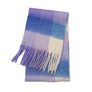 Detail shot of purple and blue plaid scarf with soft knitted texture and long tassels
