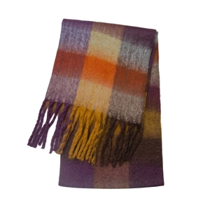 Close-up of thick winter scarf featuring purple plaid patterns and long fringe tassels