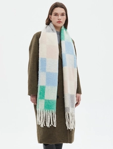 Dettaglio della sciarpa in maglia a scacchi spessa con lunghe frange blu e beige