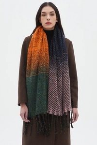 Dettaglio di sciarpa in maglia spessa con blocchi multicolore e frange su cappotto