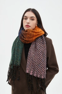 Dettaglio di sciarpa a maglia grossa con blocchi multicolore e texture con frange