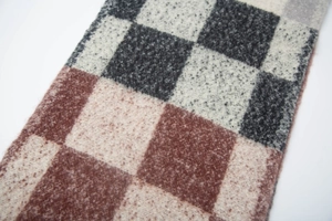 Dettaglio di sciarpa spessa a quadri in filato bouclé nero e beige con trama a maglia