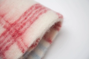 Macro dettaglio di una sciarpa spessa a quadri rossi e bianchi in finto mohair