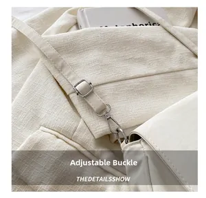 Detail of adjustable silver buckle and lobster clasp on white textured shoulder bag