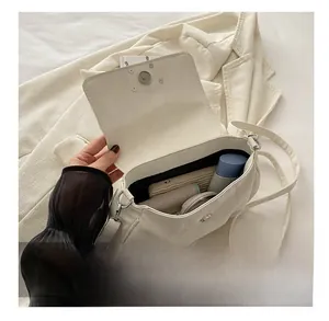 Internal storage capacity of a white textured leather shoulder bag for daily essentials