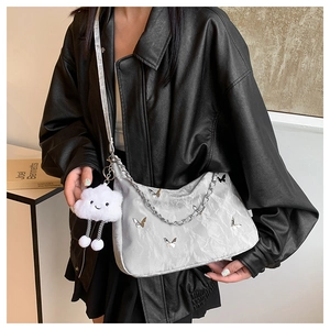 Detail of silver pleated crossbody bag with butterfly ornament and plush cloud charm