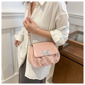 Detailed close-up of pink pleated crossbody bag with silver butterfly metal buckle