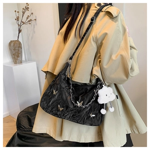 Elegant black pleated shoulder bag with silver butterfly charm and plush cloud keychain